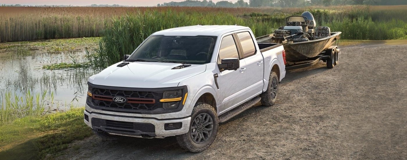 White 2025 Ford F-150 Tremor towing a boat